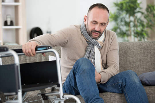 disabled man moving his leg on to the sofa