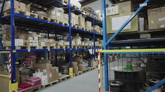 Warehouse with shelves stocked with cartons, cables, and industrial supplies