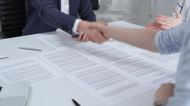 Business executives shaking hands, sealing an agreement after successful negotiations in a bright office, symbolizing partnership, collaboration, and a mutually beneficial deal signing