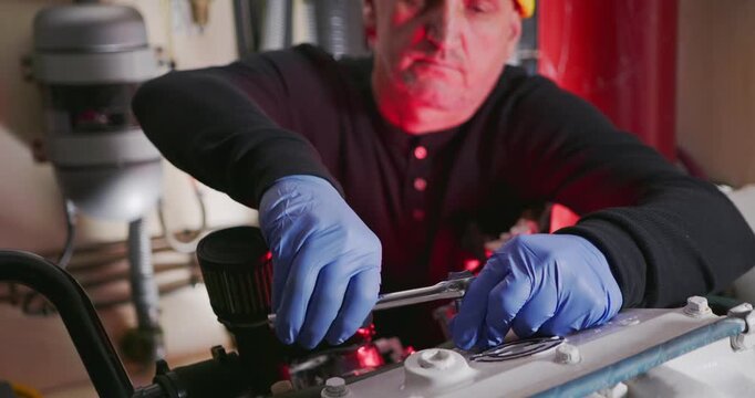 Technician Tightens Engine Bolts in Mechanical Room