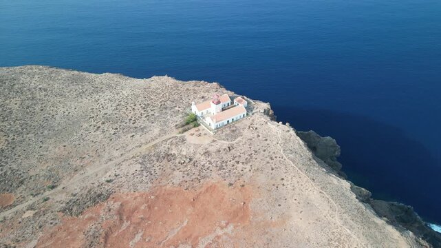 Aerial drone view over a rocky tiny island (Ilheu) with a light house. Volcanic scenic view in Porto Santo island, Madeira, Portugal