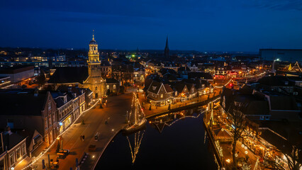Fototapeta premium Aerial from illuminated old boats in Lemmer in Friesland the Netherlands at night