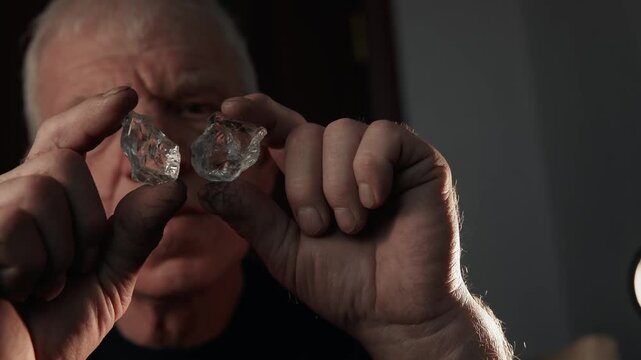 Rough diamond held between fingers of jeweler during close inspection.