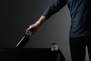 Man picks up a bottle of rum.