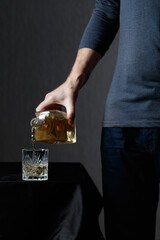 Man pouring strong alcoholic drink in glass.
