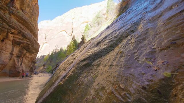 Low angle shot of the Virgin River flowing through the towering sandstone walls of The Narrows in Zion National Park, Utah
