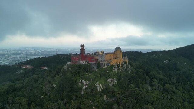 Aerial drone view around Pena Palace, a cozy colorful castle from ex Portuguese monarchy. Sintra town, Lisbon, Portugal