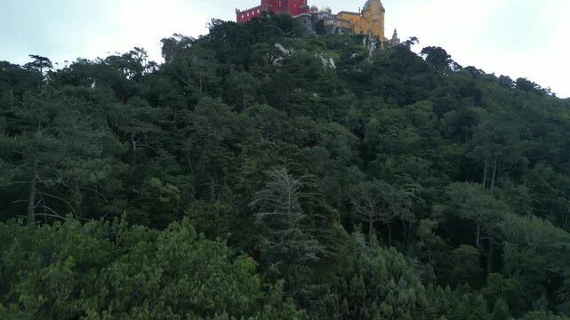 Aerial drone view around Pena Palace, a cozy colorful castle from ex Portuguese monarchy. Sintra town, Lisbon, Portugal