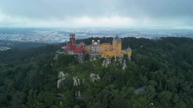 Aerial drone view around Pena Palace, a cozy colorful castle from ex Portuguese monarchy. Sintra town, Lisbon, Portugal