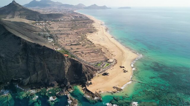 Stunning aerial view of Ponta da Calheta, Porto Santo island, Madeira, Portugal. Long sandy beach and mountains. Paradise with transparent water