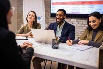 Professional hiring committee conducting a job interview in a modern corporate office.