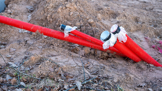 Close-up of red corrugated utility conduits at a construction site