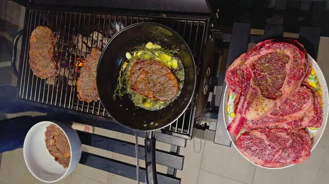 barbecue party outdoors, cooking stacks of grilled meat, rib eye steak, garlic, rosemary, butter in a pan, pieces of raw meat