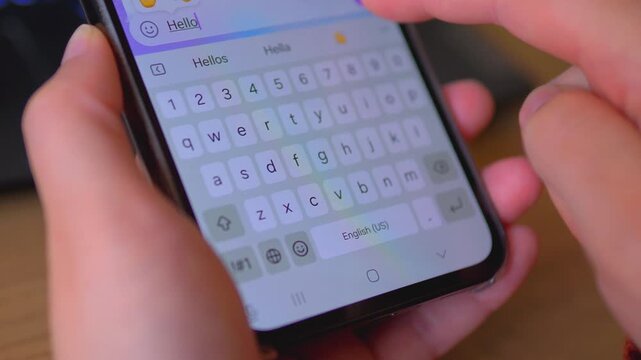 Person Typing Hello Message on Smartphone Touchscreen Keyboard &mdash; Mobile Communication Digital Lifestyle Concept