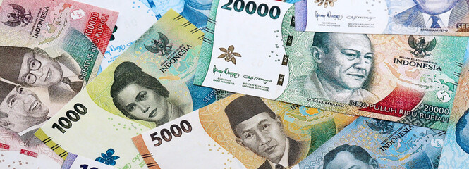 Indonesian rupiah money banknotes pile on table. Indonesia bills of IDR currency close up © Larysa