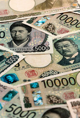 Japanese yen money banknotes pile on table. Japan bills of JPY currency. Concept of economy © Larysa
