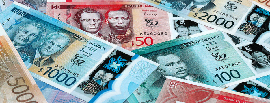 Jamaican dollar money banknotes pile on table. Jamaica bills of JMD currency close up