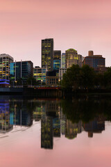 Fototapeta premium Melbourne city sunset skyline with high rising modern buildings and water reflections over the Yarra River Marina, Victoria, Australia