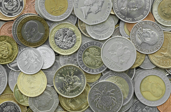 Pile of global currencies, various coin types visible up close. Different nations money together