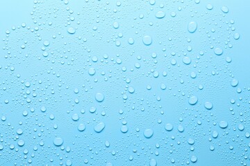 Many water drops on light blue background, top view