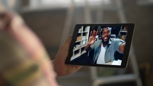 Happy startuper greeting tab screen at office closeup. Man talking videochat