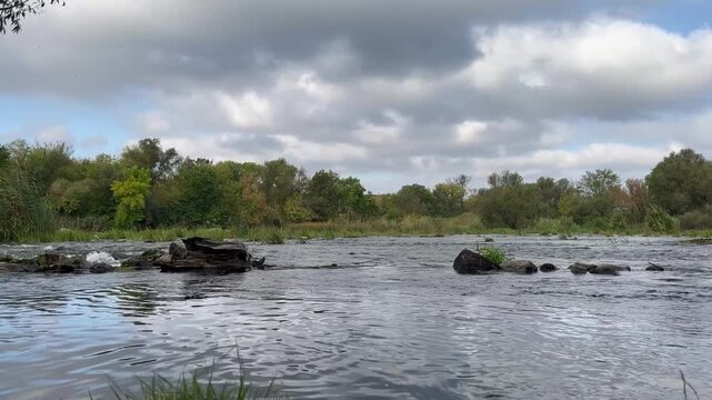 Landscape of a fast river with stones in the middle, midsummer