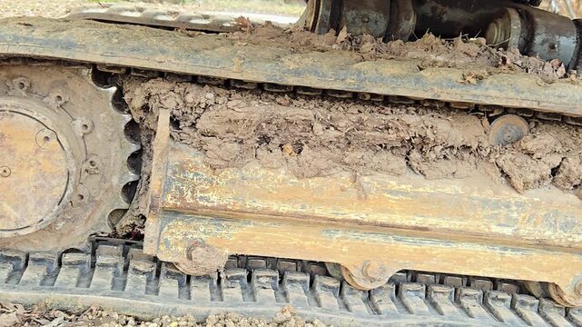 Dirty caterpillar tracks of construction machinery on soil.