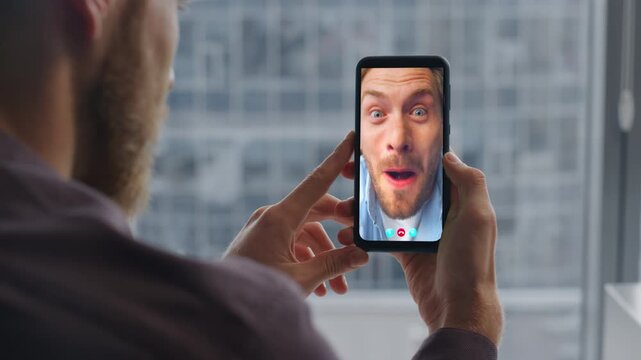 Friends chatting conference app online at home. Closeup man hands holding phone