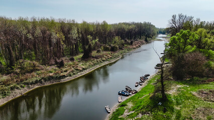 Fototapeta premium Spring fishing on calm Danube oxbow with boats and reflections