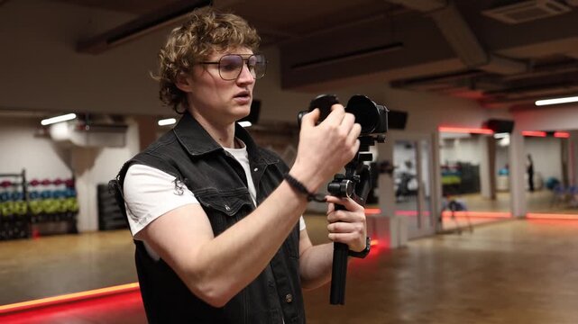 Cameraman in studio holding camera on gimbal finishes shooting then realizes lens cap was on and nothing was recorded reacts with surprise and frustration