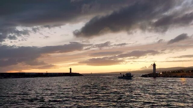 Scenic View of a Traditional Fishing Boat Returning to Sarkoy Harbor During a Golden Sunset, Dramatic Stormy Clouds Over the Marmara Sea, Tekirdag, Turkey.