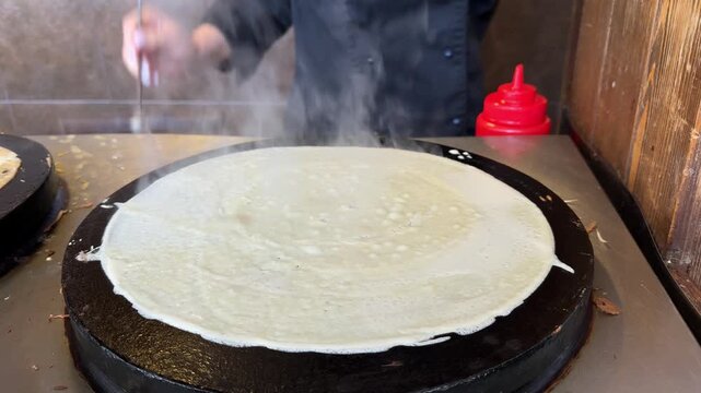 Buttering hot freshly baked crepes. Cooking pancakes at home. Delicious food, breakfast