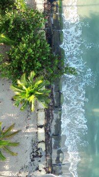 Vertical aerial top down view of turquoise Caribbean sea and white sand beach in Rincon del Mar, Colombia