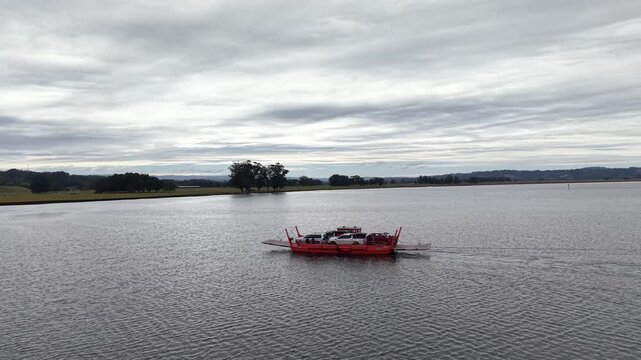 Aerial view of a ferry transporting overland 4x4 vehicles across a river in the south of Chile.