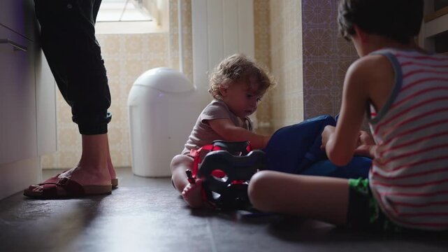 Toddler sitting on kitchen floor taking leather glasses case from purse curious childhood moment exploring personal objects and everyday items in home environment