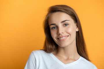 Obraz premium Beautiful young smiling woman with clean perfect fresh skin and white teeth smile. Portrait of beauty model girl with natural make up, formed eyebrows and long eyelashes. Spa, skincare and wellness