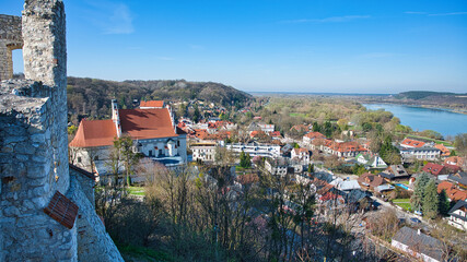 Malowniczy widok na Kazimierz Dolny, urokliwe, historyczne miasto w Polsce, widziany z ruin zamku. Zdjęcie ukazuje piękną panoramę rzeki Wisły, kolorowe budynki Starego Miasta oraz zielone otoczenie. © BMC