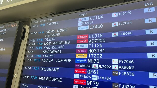 Narita International Airport flight arrival information board displaying international schedules for airlines including Emirates JAL and Qantas - Chiba, Japan, October 29, 2025