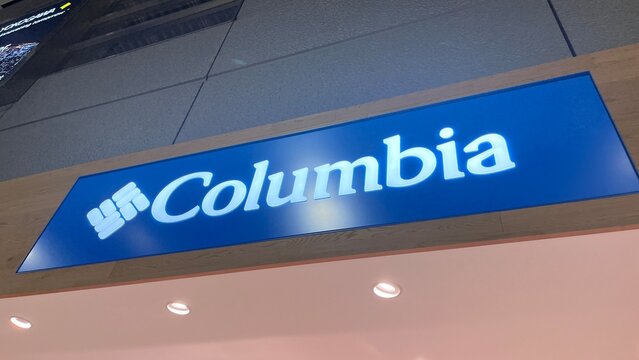 Columbia Sportswear illuminated store sign near a Starbucks coffee shop interior within Narita International Airport terminal building - Chiba, Japan, October 29, 2025