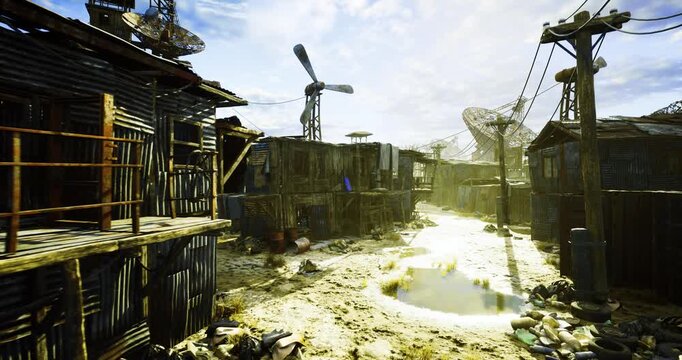 wind turbine and improvised machinery over settlement, blades silhouetted against bright sky with glint on corrugated roofs, wiring and makeshift generator
