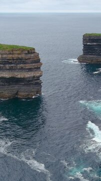Aerial vertical view of stunning Downpatrick Head coastal landmark with iconic Dun Briste sea stack. Cliffs and waves, raw beauty of Ireland's west coast. Wild Atlantic Way Signature Discovery Point.
