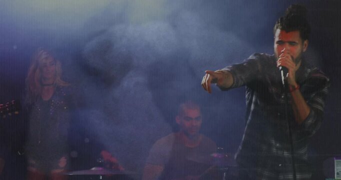 Lead singer stepping forward on band cue in music performance, moving center and singing into mic
