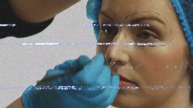 Pen touching nose starting gloved hand marking patient face, checking symmetry for surgery