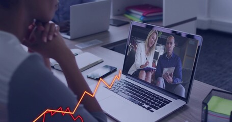 Fototapeta premium Watching worker viewing white-blazer presenter on laptop at office desk, with notebook tablet chart