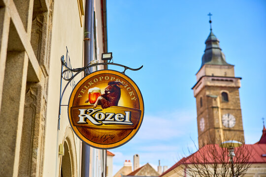 Velkopopovicky Kozel beer sign with historic clock tower in background. March 20, 2026, Slavonice, Czech Republic