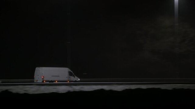 Delivery van moving along a dark road at night in winter conditions with motion blur