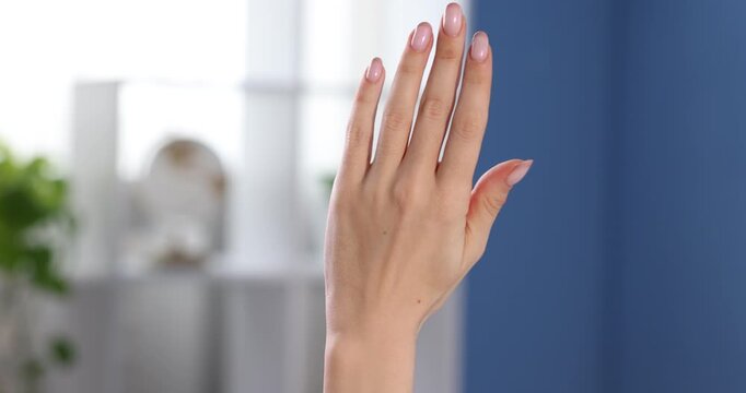 Woman counting on fingers at home, closeup