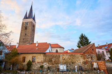 Obraz premium Historic church and rustic stone wall in charming european town