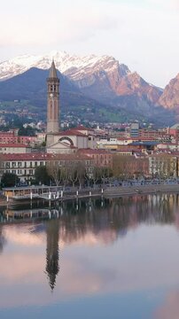 Aerial beautiful sunset cityscape of Lecco town and resort. Picturesque waterfront of Lecco town located between famous Lake Como and scenic Bergamo Alps mountains. Vacation destination in Italy.