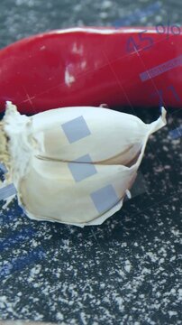 Vertical video: Camera panning chilis, garlic, tomatoes, HUD aligning over sauce bowl for cooking